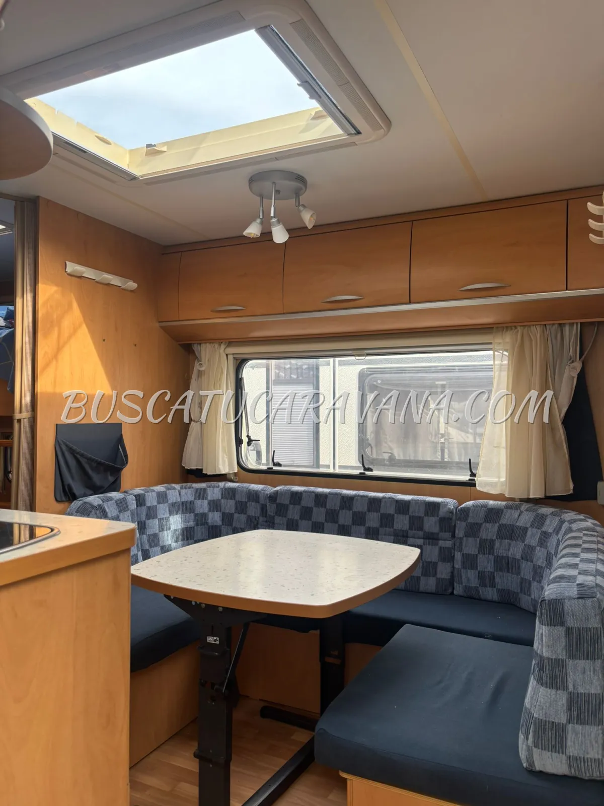 Interior salón caravana con sofá rinconera y mesa de Caravanas Sun Roller Tango Luxe 495